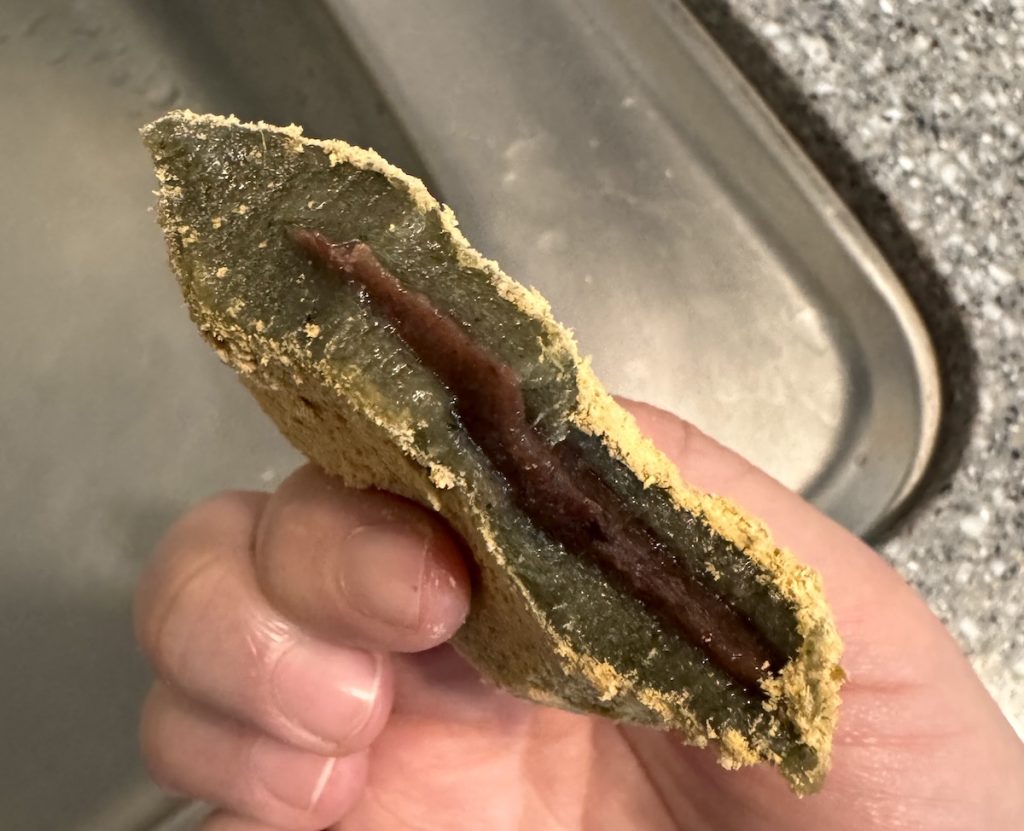 Ssuk-tteok's naturally dark green appearance with sweet red bean paste filling.